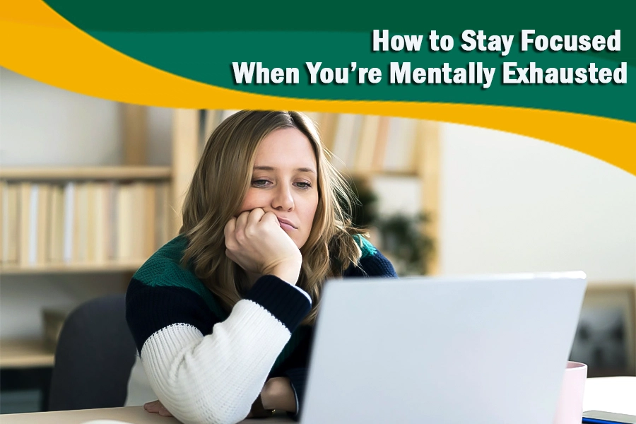 Tired woman looking at a laptop, struggling to stay focused when mentally exhausted.