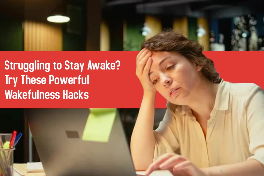 Exhausted woman at a desk using a laptop at night, resting her head in her hand while working.